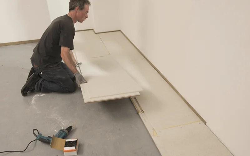 Handwerker verlegt Platten auf dem Boden