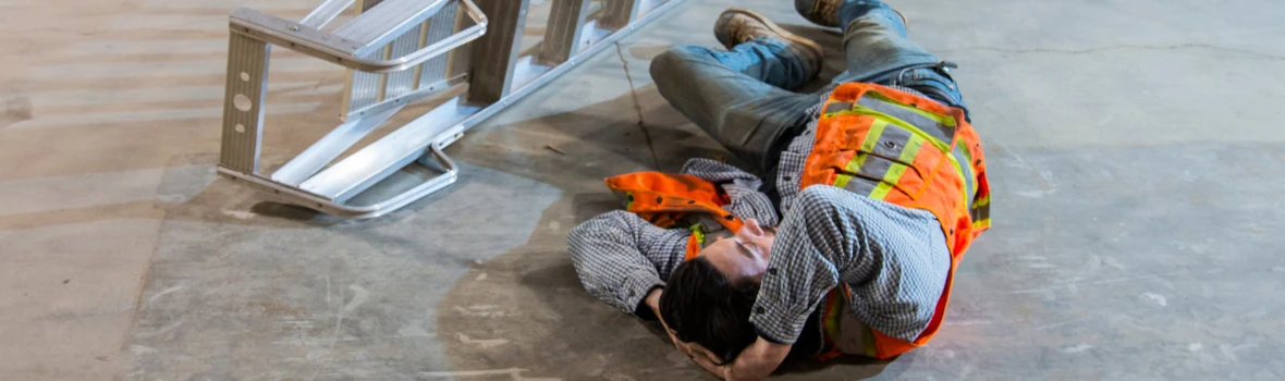 Handwerker der von Leiter gefallen ist und sich den Kopf hält