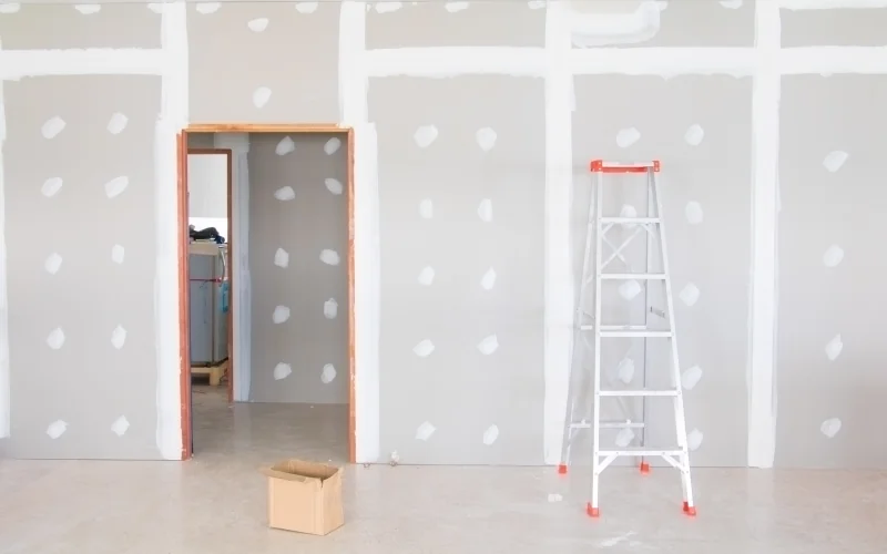 unbehandelte nichttragende Wand mit einer Leiter davor 
