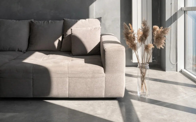 Sonne scheint in modernes Wohnzimmer mit Beton Bodenfliesen als Trend 2025 