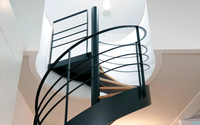 schwarze Wendeltreppe die nach oben in ein Dachgeschoss führt