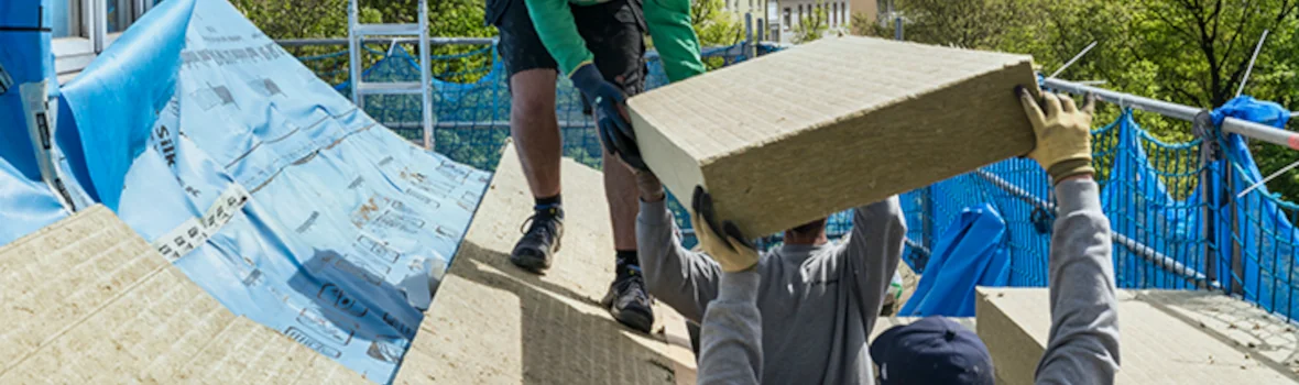 Handwerker decken ein Dach mit Steinwolleplatten ein