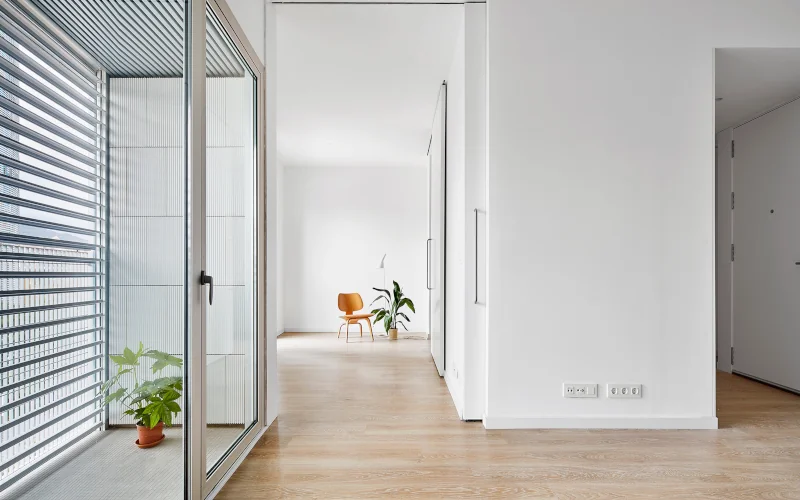 minimalistisches Arbeitszimmer mit weißen Wänden und Holzfußboden