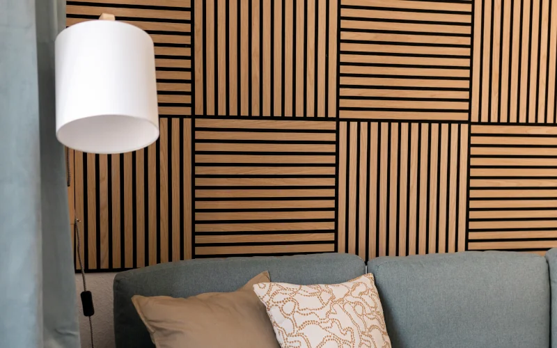 Wohnzimmer mit Sofa und Lampe und Akustikpaneelen an der Rückwand