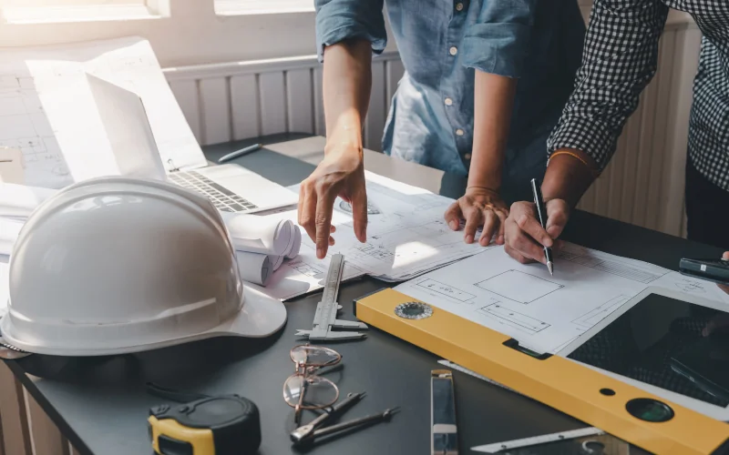 Nahaufnahme von Bauherren, die an einem Plan arbeiten und sich dazu austauschen 