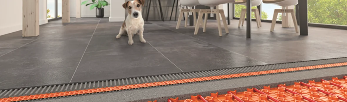 Hund sitzt auf gefliestem Boden mit Fußbodenheizung darunter