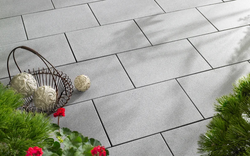 graue Terrassenplatten mit Busch und Dekoration