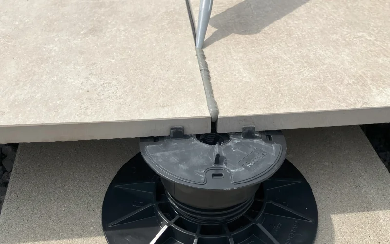 Terrassenplatten auf einer Stelze werden verfugt