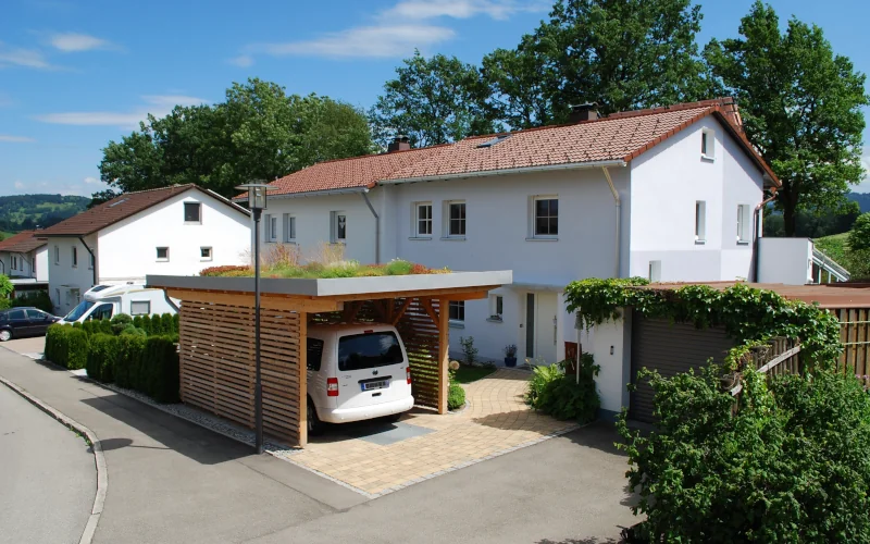 Einzel-Carport mit Dachbegrünung und Wohnhaus im Hintergrund