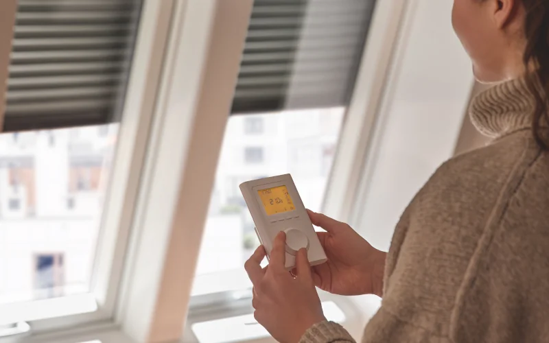 Frau steuert Dachfenster mit einer smarten Bedienung