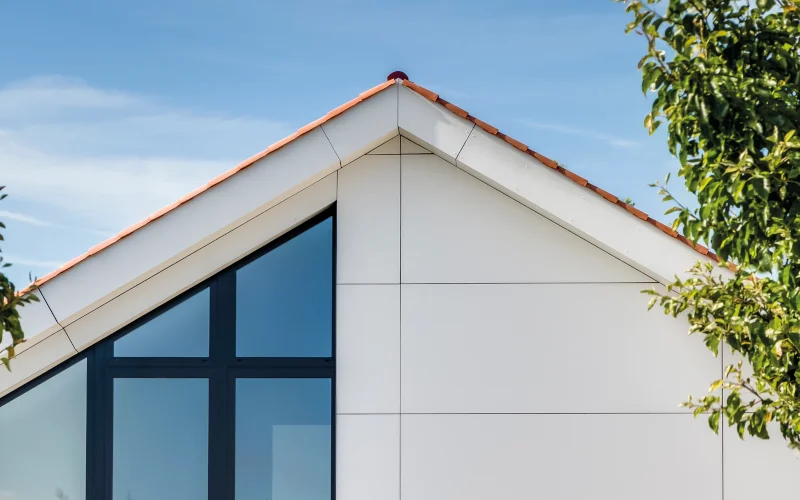 Dachgiebel eines Hauses mit Satteldach und halber Fensterfront