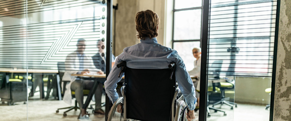 Rollstuhlfahrer der in ein Büro reinfährt