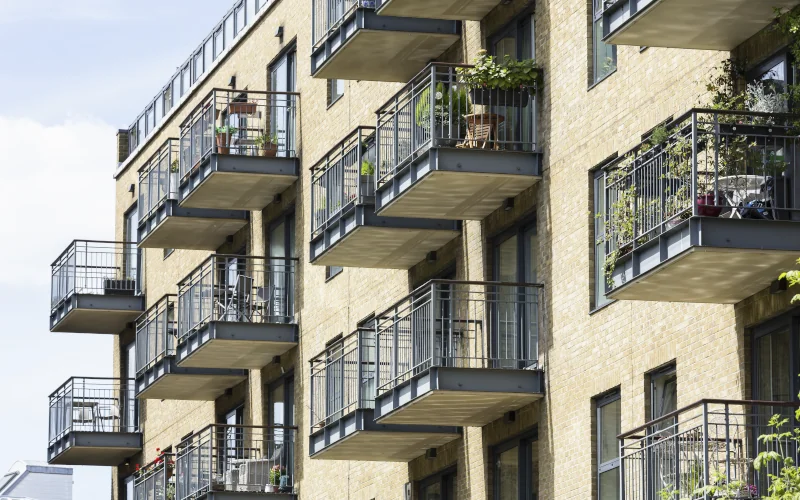 Reihenhaus mit heller Fassade und Balkonen mit Pflanzen