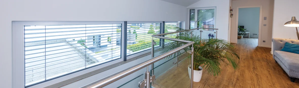 schmale Fenster mit geöffneten Rollläden am Treppenbereich eines Wohnhaus 