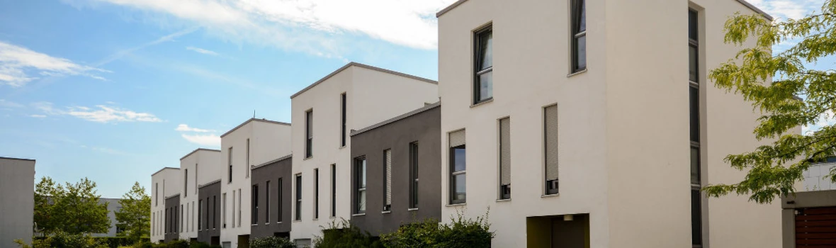 Flachdach-Reihenhaus mit beigefarbener und brauner Putzfassade