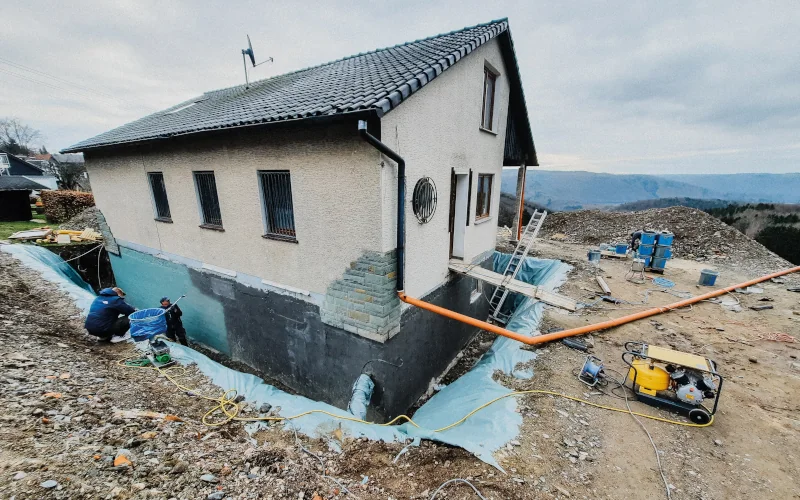 Dämmung wird rund um Wohnhaus am Kellergeschoss verteilt
