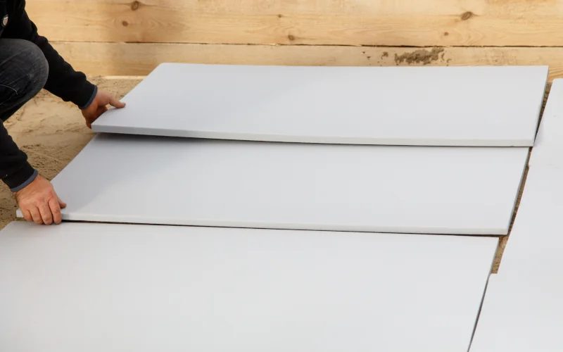 Mann legt verschiedenen Platten auf dem Boden aus