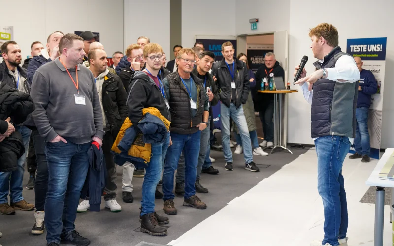 Mann hält einen Vortrag vor Menschen auf einer Messe der Firma Botament