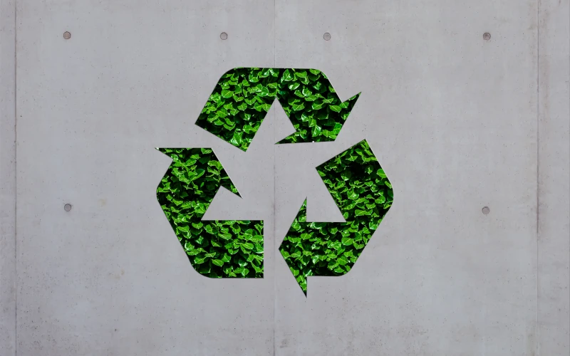 Grünes Recyclingsymbol auf einer Betonwand