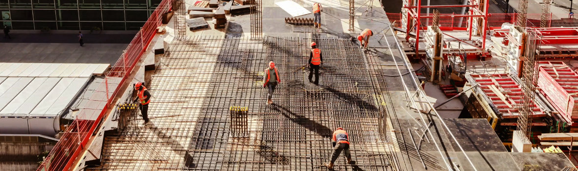 viele Bauarbeiter und Baumaterialien auf einer Baustelle auf einem Gebäude