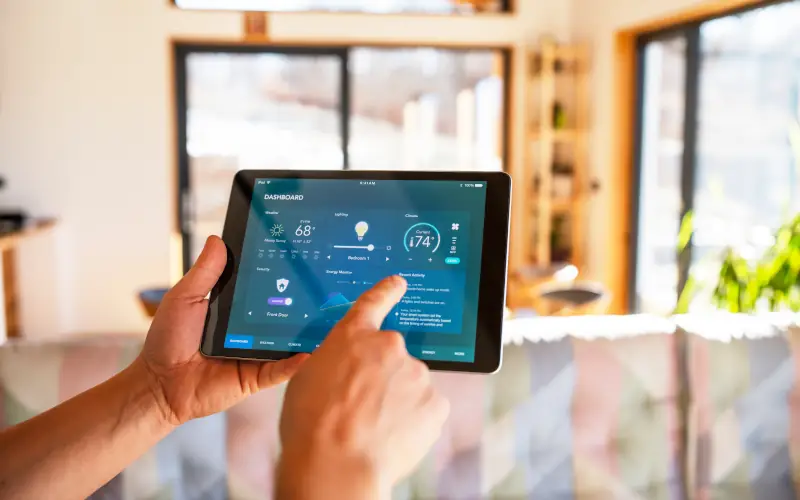 Person bedient Smart-Home-System auf Tablet im modernen Wohnraum.
