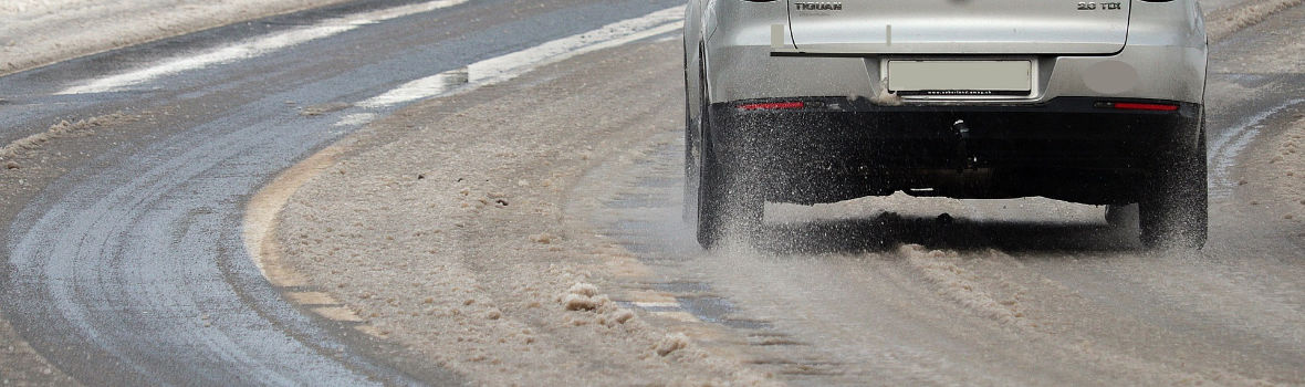 Auto fährt über eine durch Schnee matschige Straße