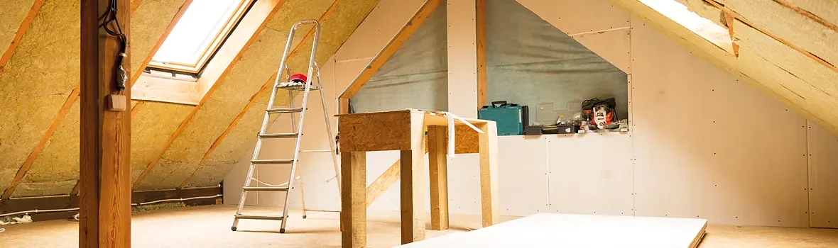 Dachgeschoss im Ausbau mit Holz und offener Dämmung an den Wänden