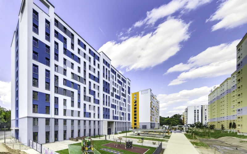 Wohngegend mit großen Wohnblöcke mit bunter Fassade und Begrünung davor