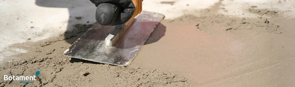 braune Masse wird mit einer Kelle auf dem Boden verstrichen 