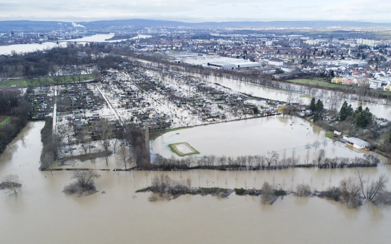 Luftaufnahme eines Überschwemmungsgebiets zeigen überflutete Flussufer eines Industriegebiets am Main, Deutschland nach starken Regenfällen