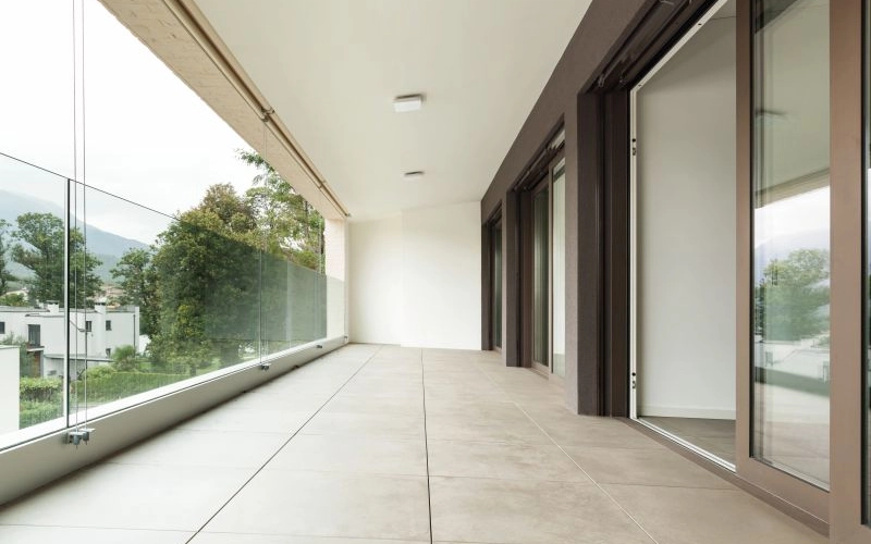 Leerer Balkon mit hellem Terrassenbelag.