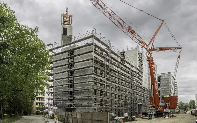 großer Wohnblock im Bau mit Kran daneben