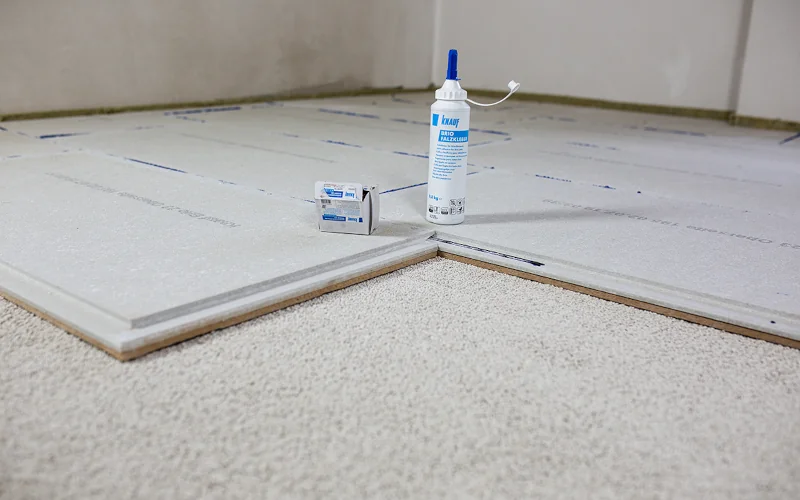 Bodenplatten liegen auf Untergrund mit Klebstoff danebenstehend