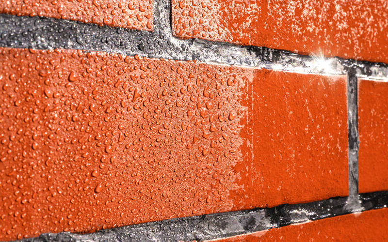 Wassertropfen auf einer Ziegelwand 