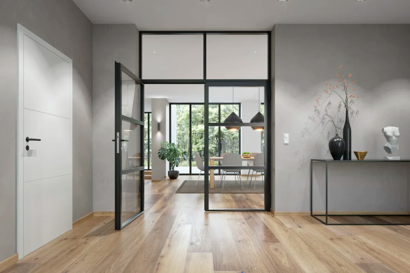 Wohnzimmer mit großer Glastür und schwarzen Rahmen
