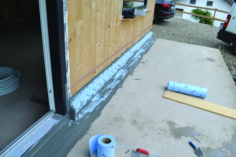 Haus mit offener Fassade entlang. Über all liegen Materialien 