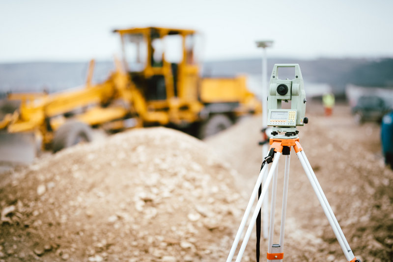 Auf einer Baustelle wird eine Vermessung vorgenommen
