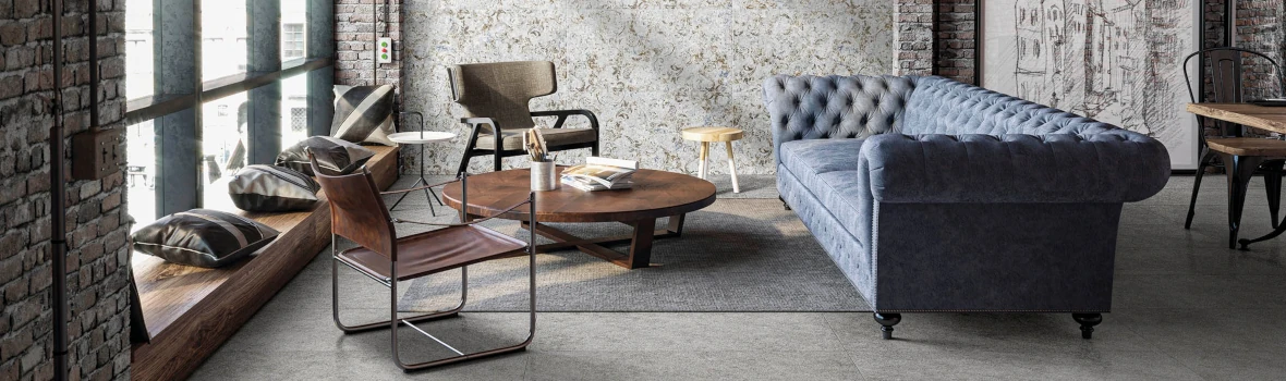 Industrielles Wohnzimmer mit blauer Couch und großen Fenstern.