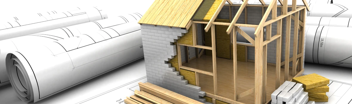 Ein Modell von einem Hausbau neben Bauzeichnungsplänen