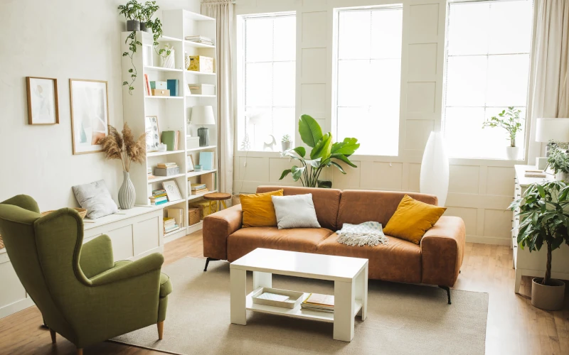 Gemütliches Wohnzimmer mit brauner Couch und Bücherregalen.