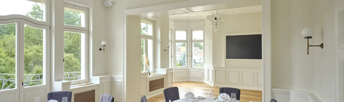 Essbereich in einem Altbau mit hohen Decken und Sitzmöbeln