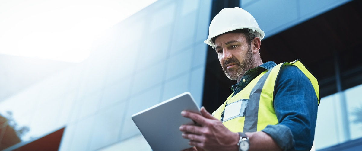 Mann auf Baustelle mit einem Tablet.