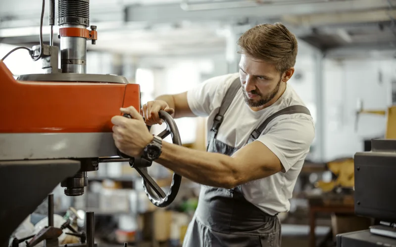 Handwerker der eine große Maschine bedient