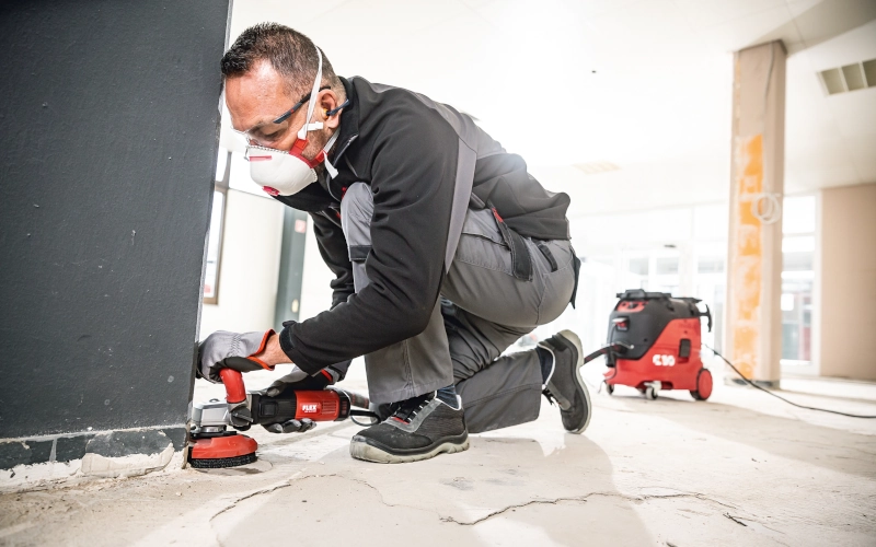 Handwerker schleift den Betonboden mit dem LDE 16-8 125R Sanierungsschleifer der Firma FLEX