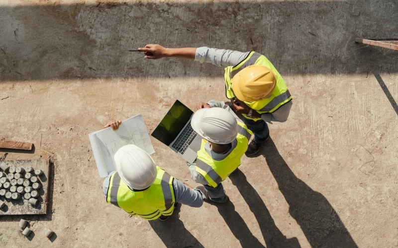 Draufsicht, Teamingenieur Gebäudeinspektion verwenden Tablet-Computer und Blaupause arbeiten auf der Baustelle