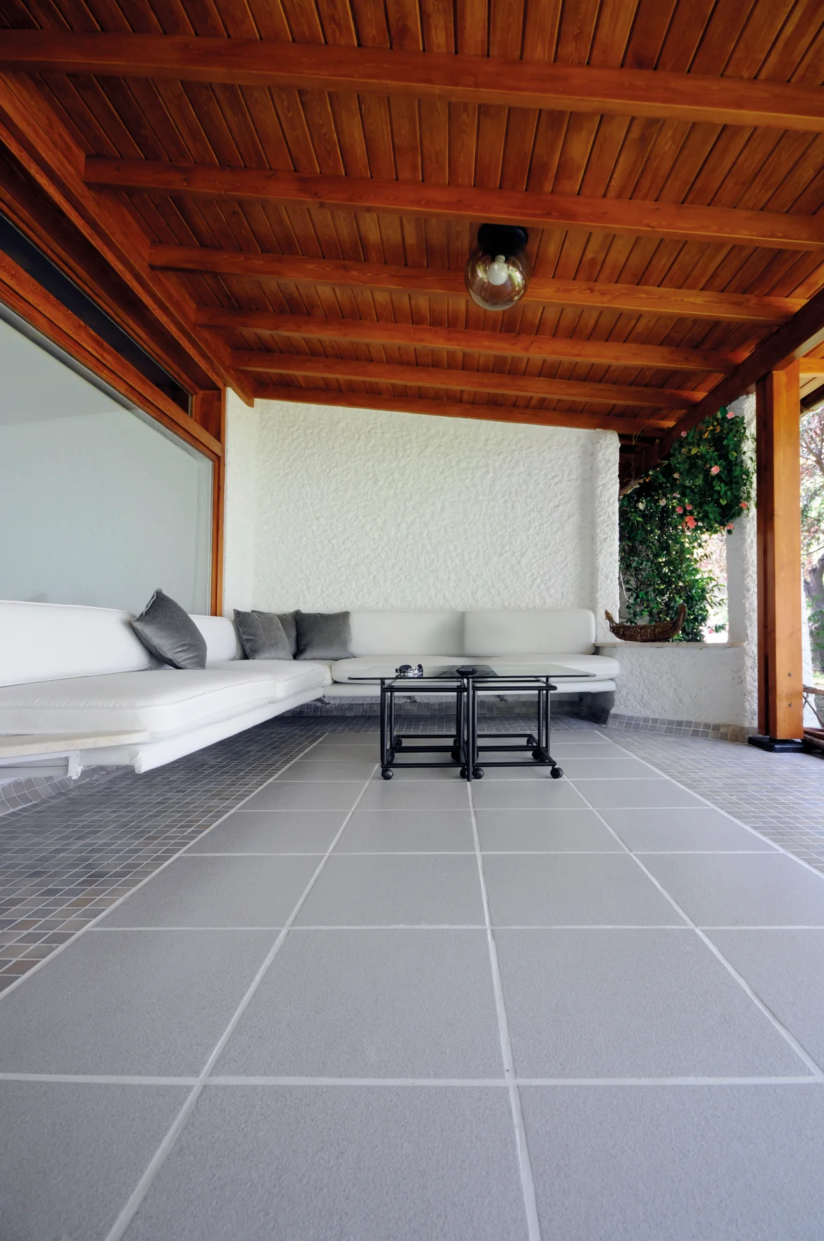 Terrasse mit einer Sitzlounge und sauber verfugten Bodenplatten in grau