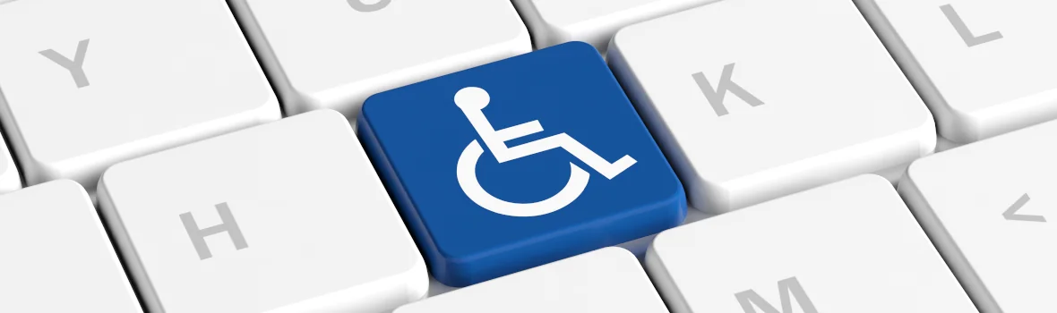 Blauer Tastenknopf mit Rollstuhlschild auf einer Computer-Tastatur