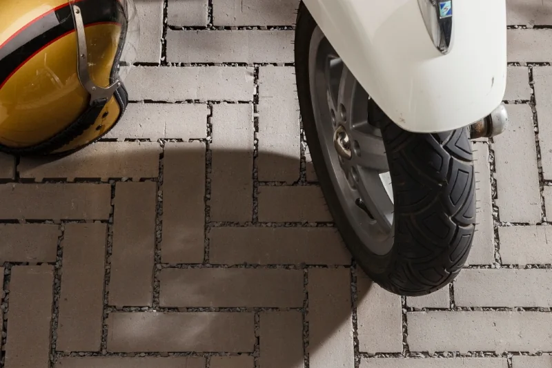 Pflasterfläche mit H-Verband-Verlegung, befahren von Motorroller