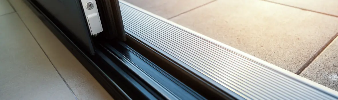Moderne Türschwelle mit geriffeltem Metallprofil, Übergang zu Terrasse.
