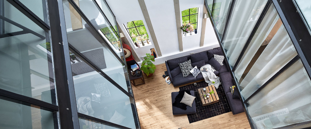 Modernes Wohnzimmer mit hohen Fenstern.